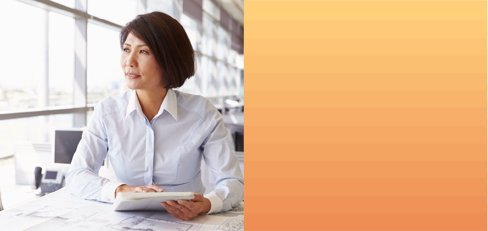 Woman works on a blueprint in an office