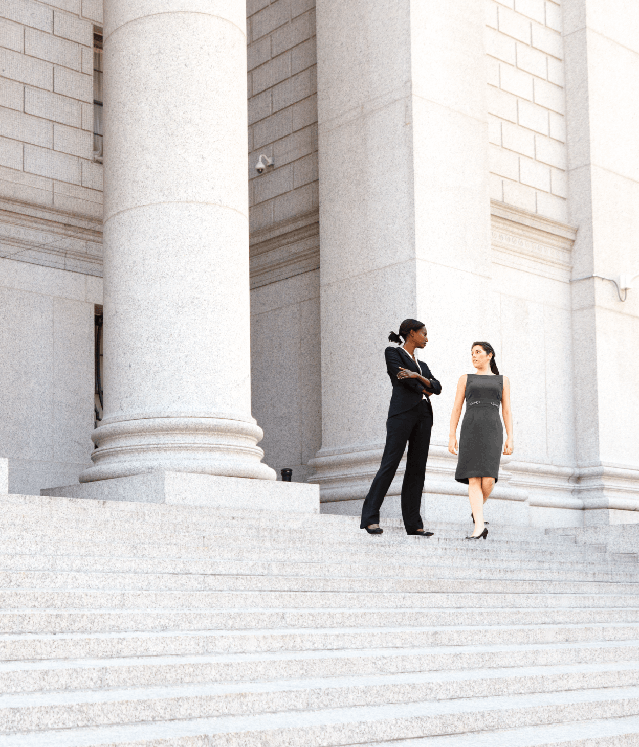Two women walking down the steps of a government building