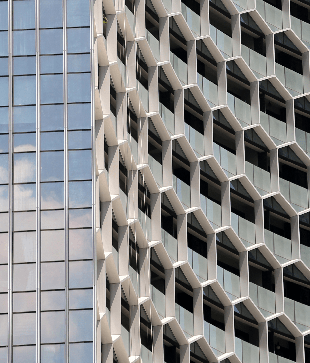 Curved office building façade with hexagonal frames over its windows.