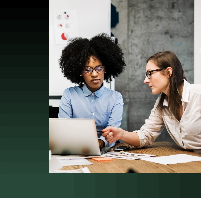 Two women going over a project on a laptop during a business meeting.
