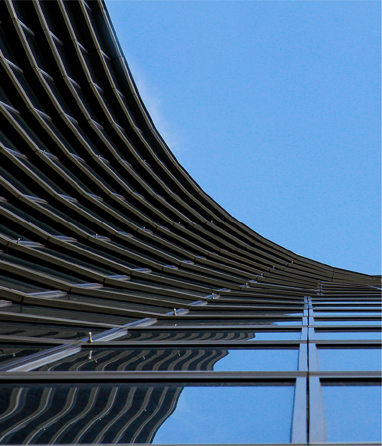 Photo of a curved office building where the viewer is looking straight up along its façade