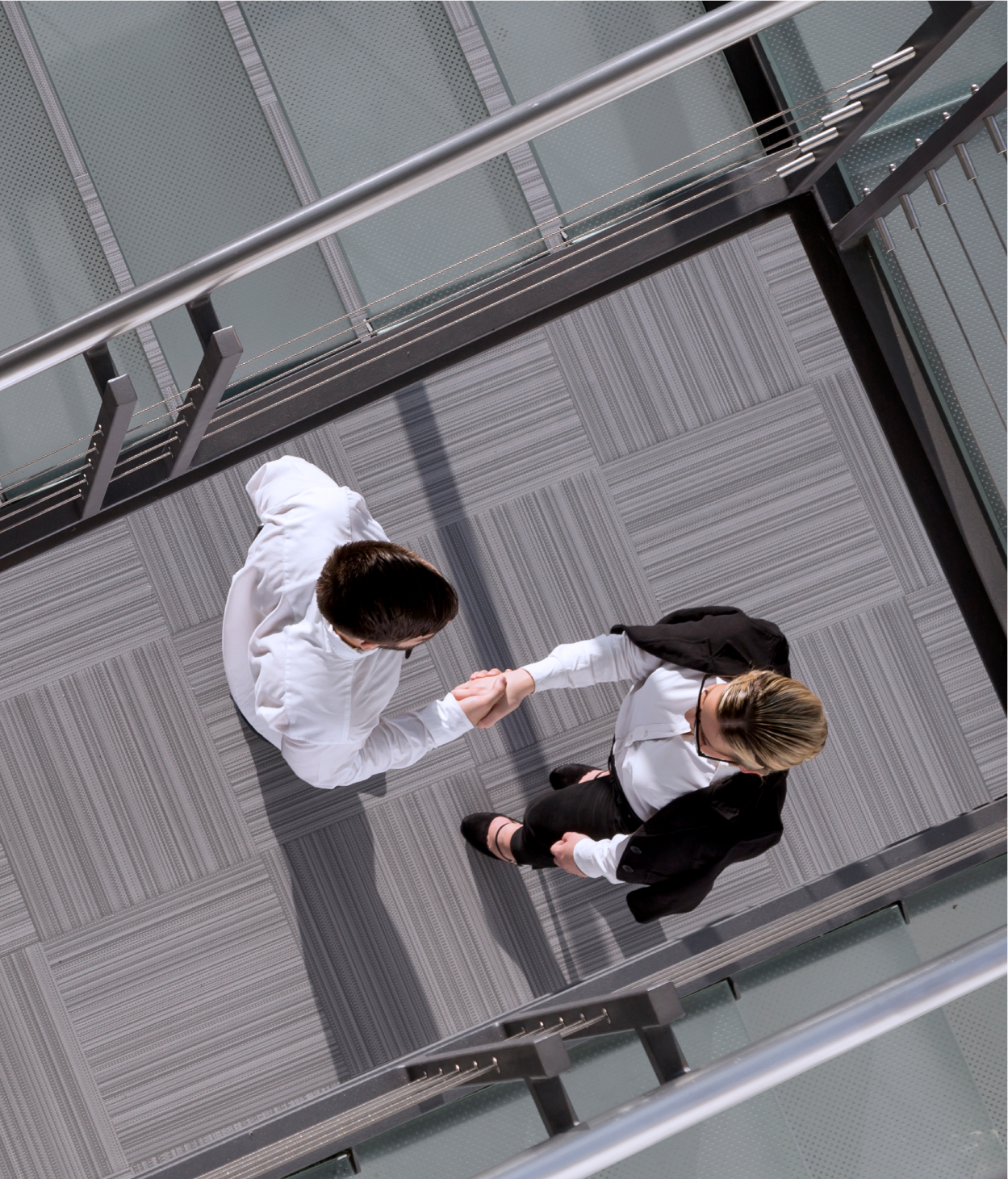 Photo of man and woman shaking hands in office space aerial view