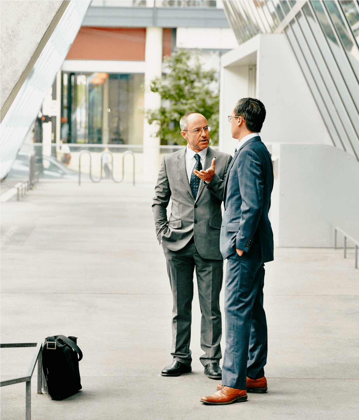 Two businessmen speaking outside of an office building