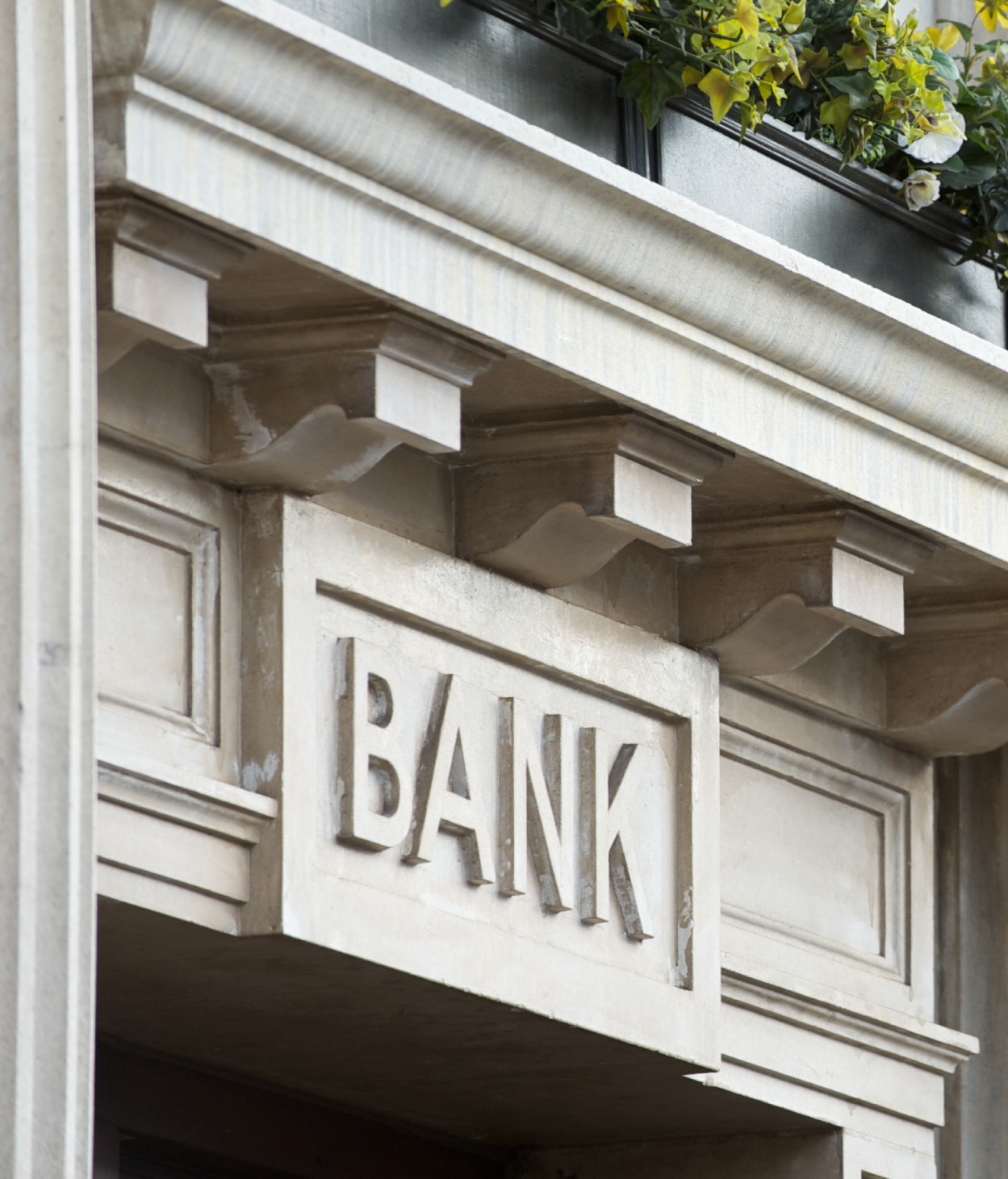 Close up of a bank sign above a neo-classical style entryway