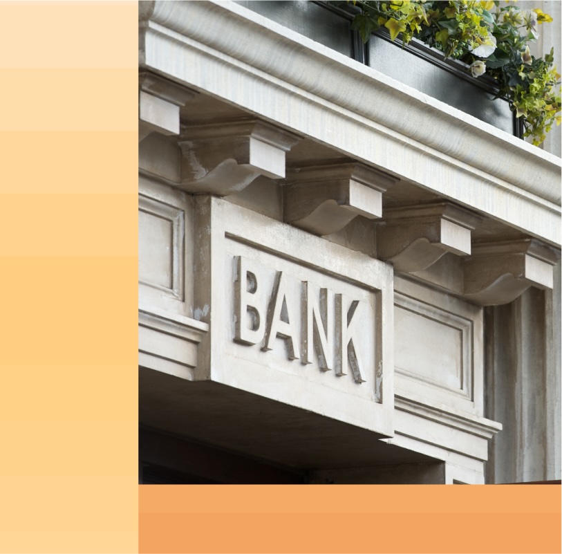 Close up of a bank sign above a neo-classical style entryway