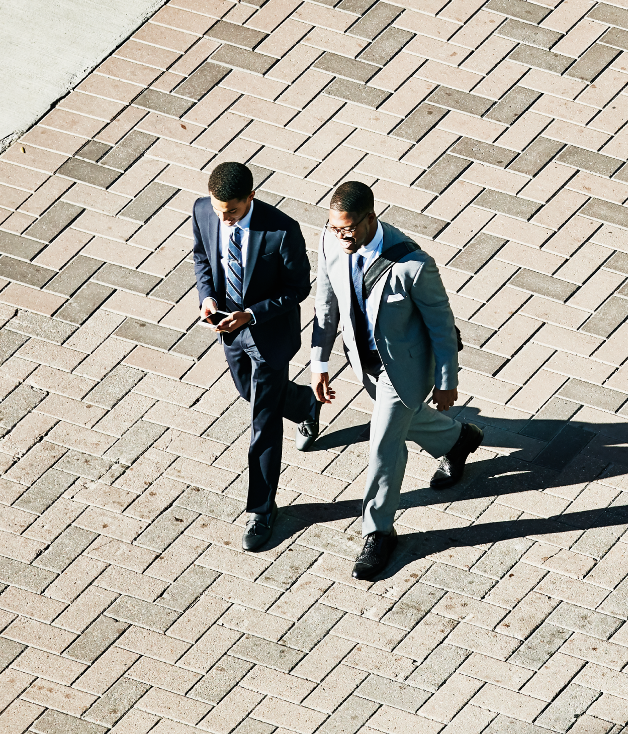 Aerial view of two people walking down the street wearing business suits