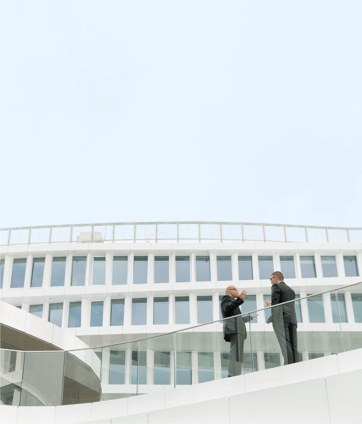 Two businessmen talking outside of an office building