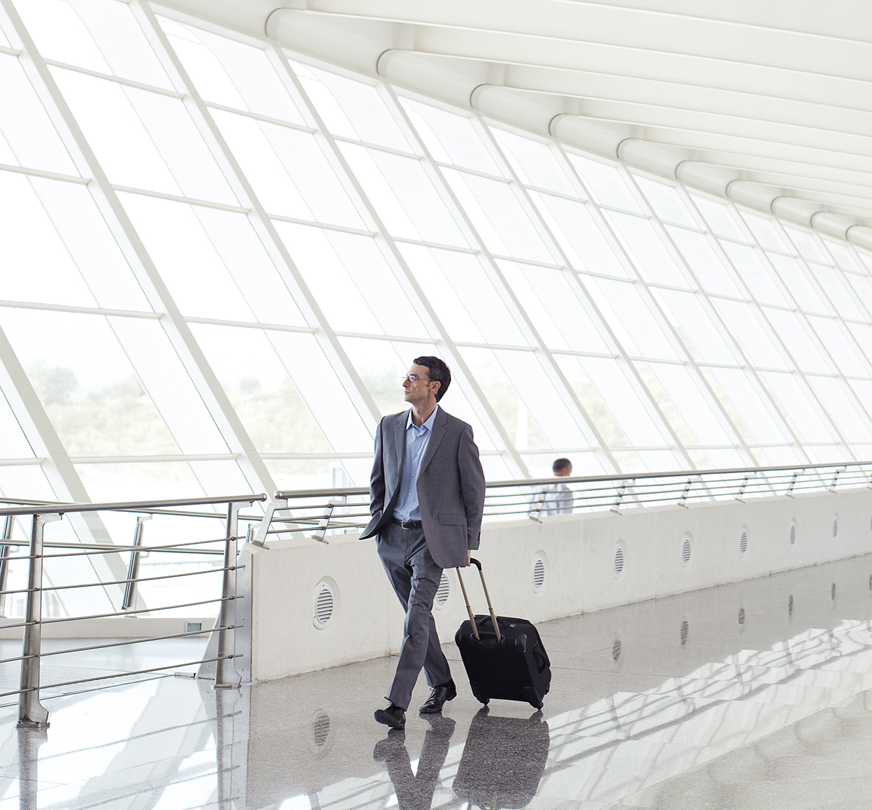 business man walking through an airport with luggage