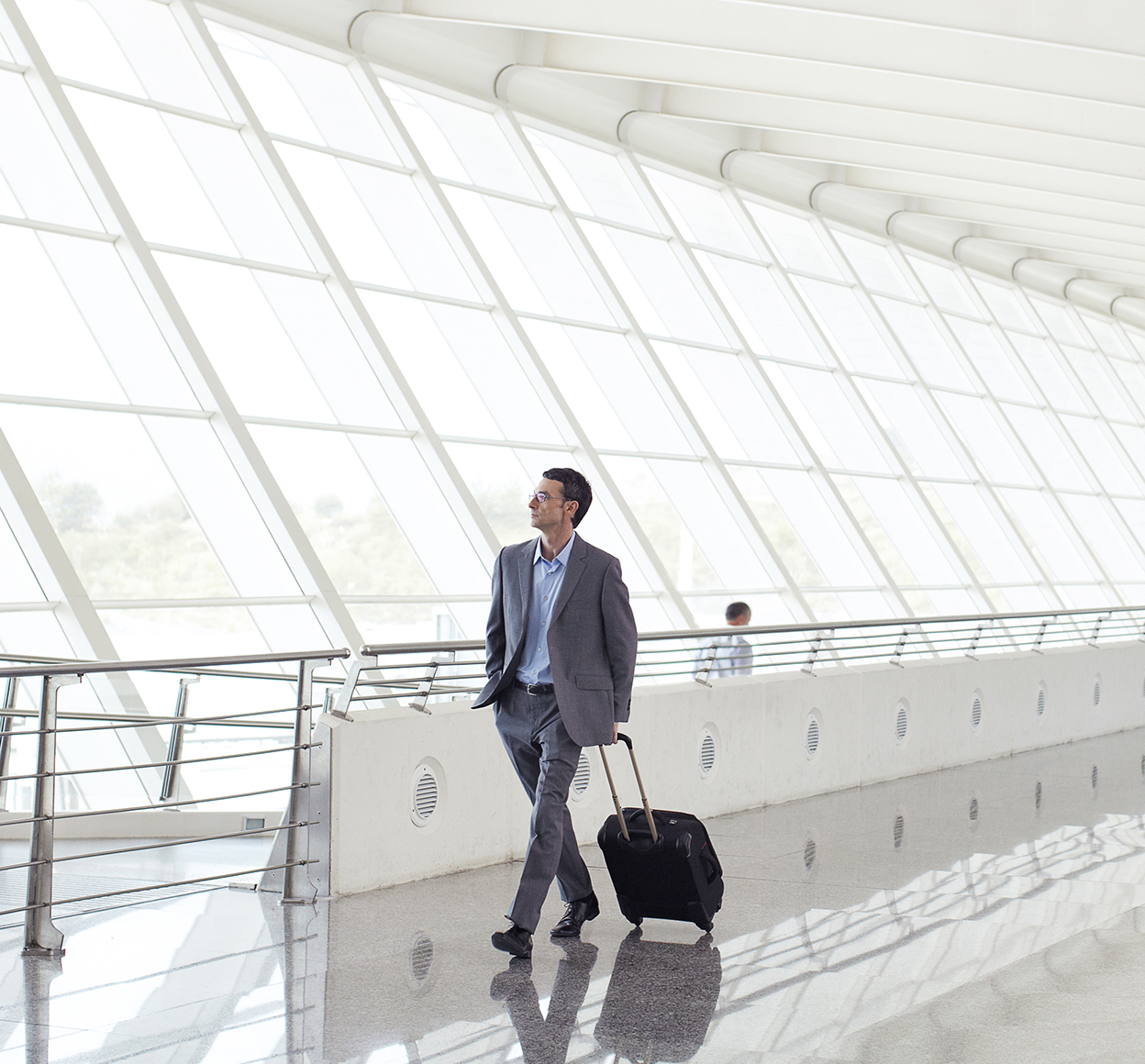 Geschäftsmann geht mit Gepäck durch einen Flughafen