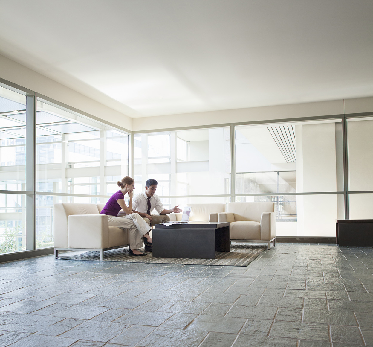 Two business people talking in office lobby