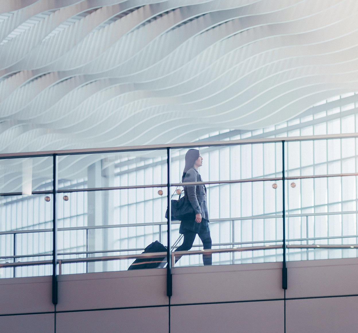 Businesswoman pulling suitcase in airport terminal