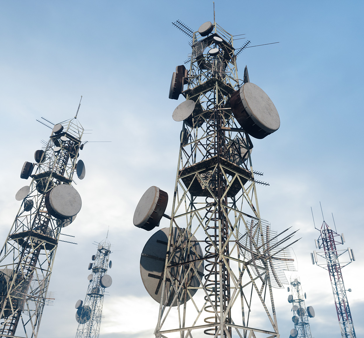 Low-angle photo of a group of radio towers