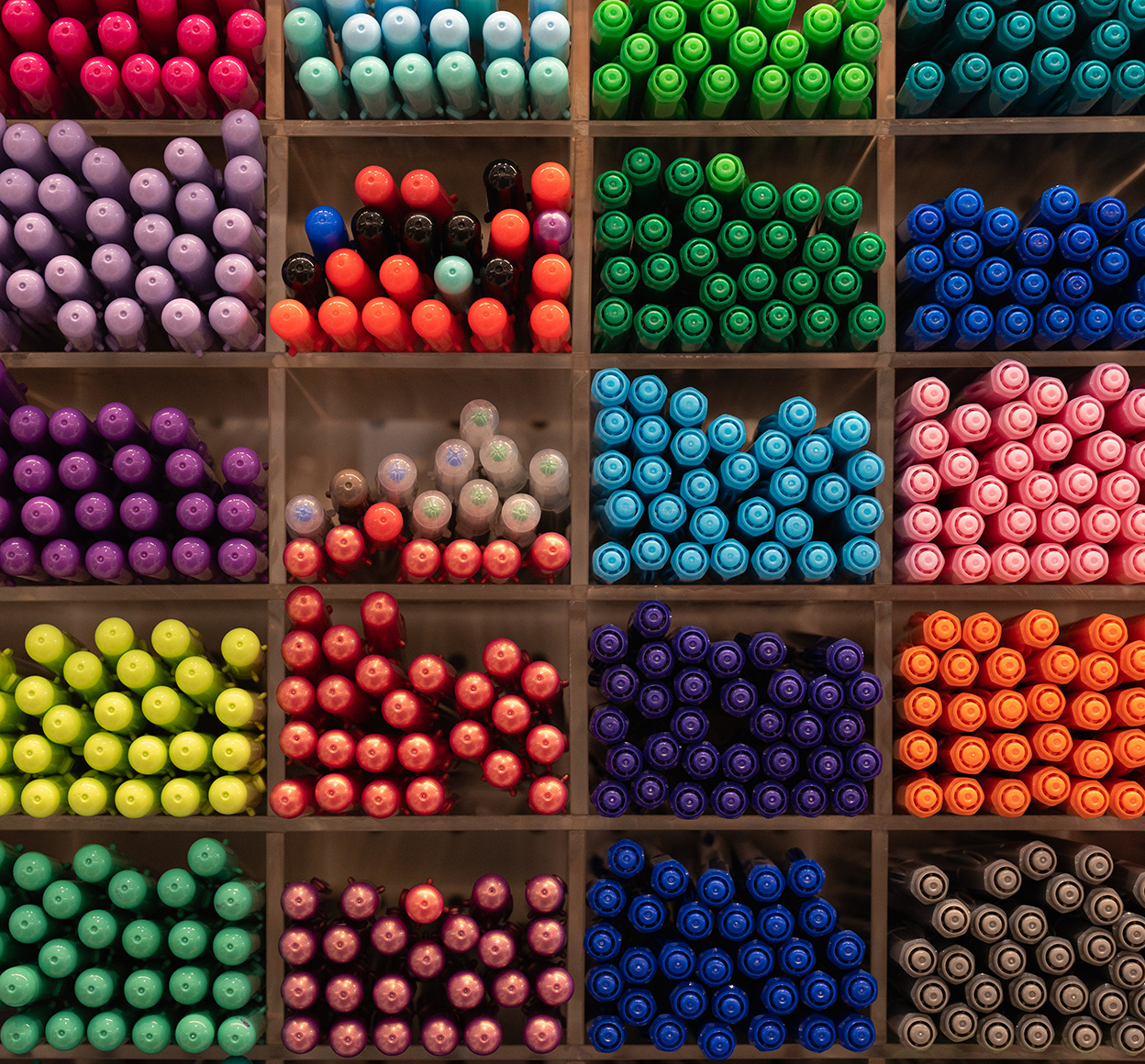 Groups of colorful pens on a shelf