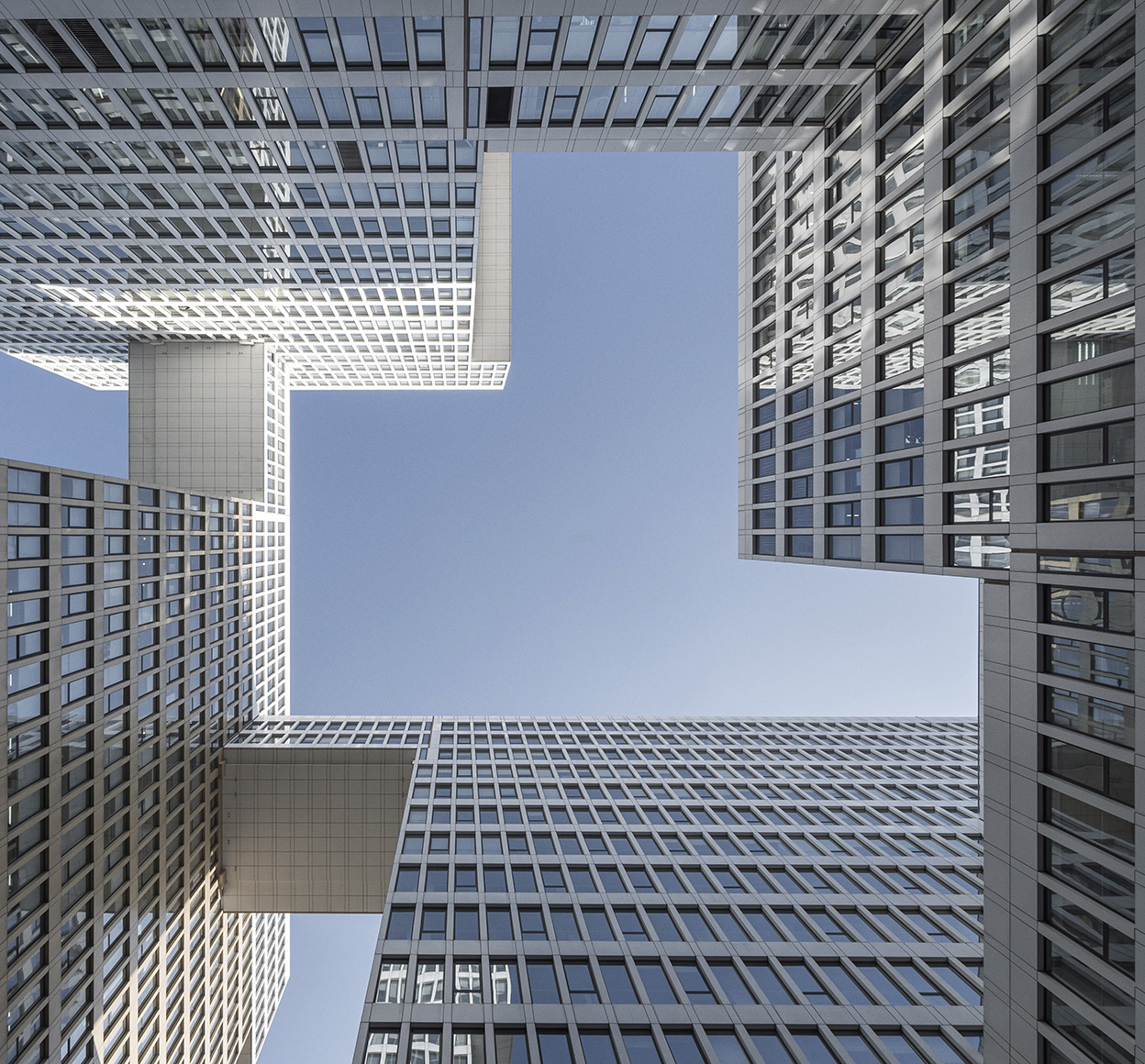 Photo looking up at connected skyscrapers