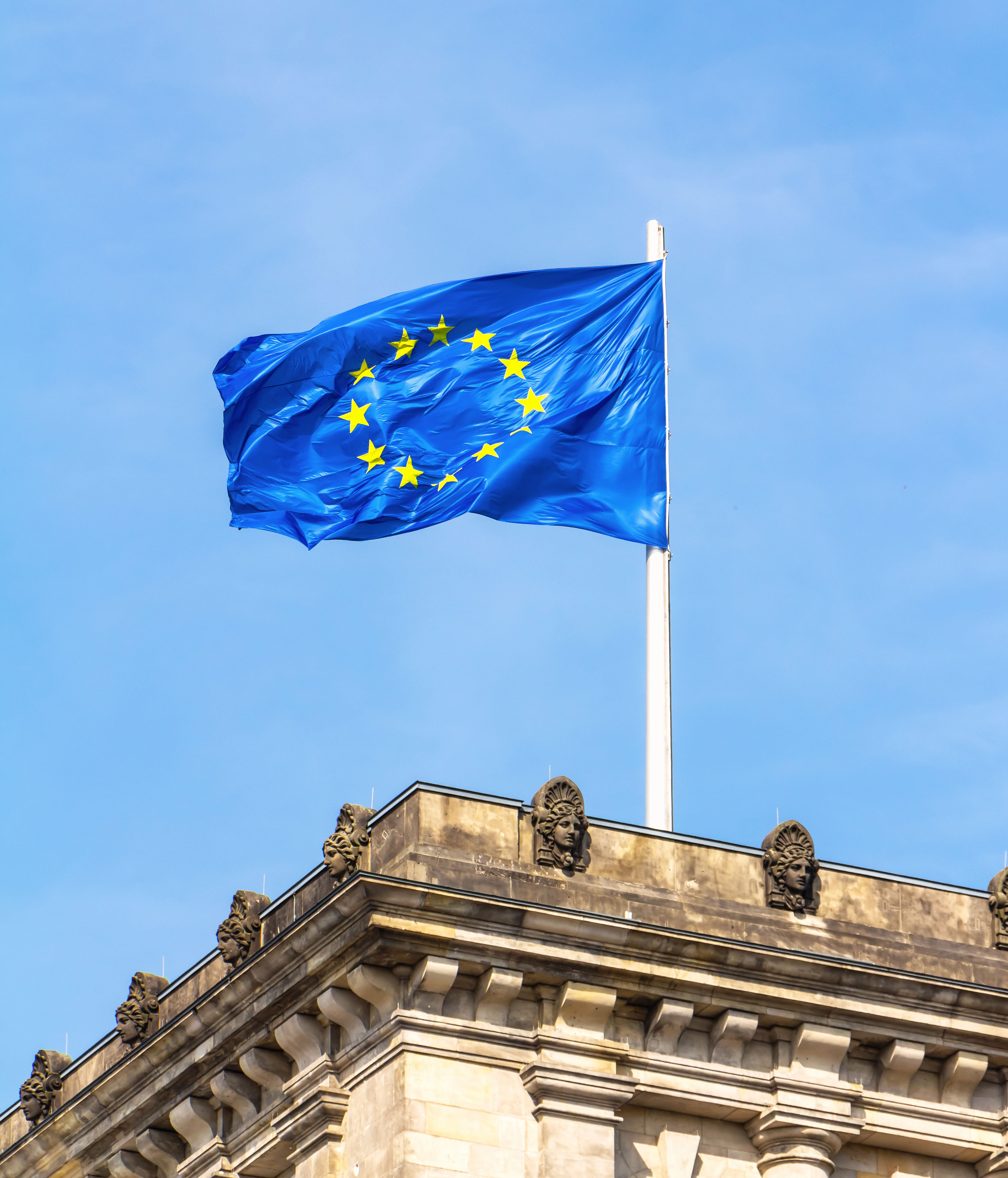 Portrait oriented OneTrust photo of the European Union flag on the Reichstag in Berlin, Germany.