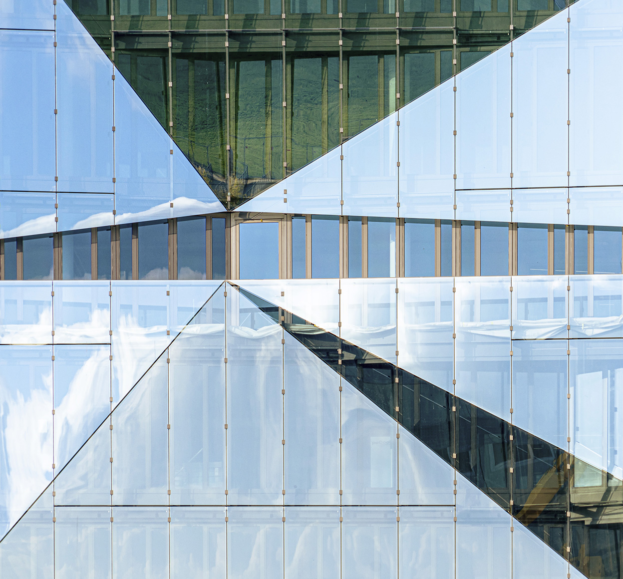 Reflection on a glass facade creates an abstract image of a neighboring office building