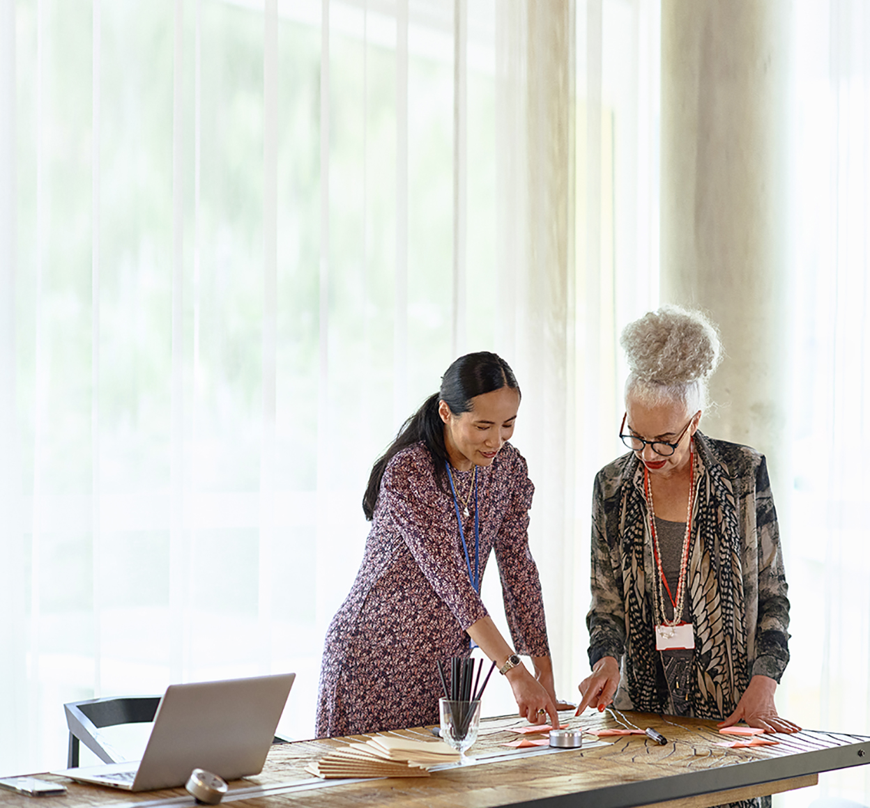 two people reviewing materials on a desk