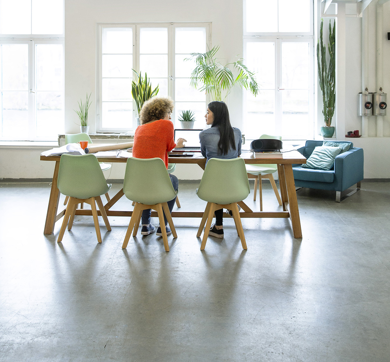 Two colleagues sitting at office table in open office