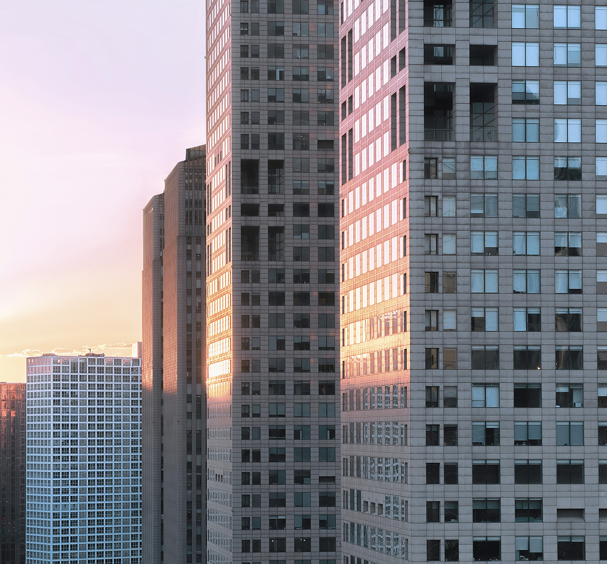 City skyscrapers reflect the light from a sunset