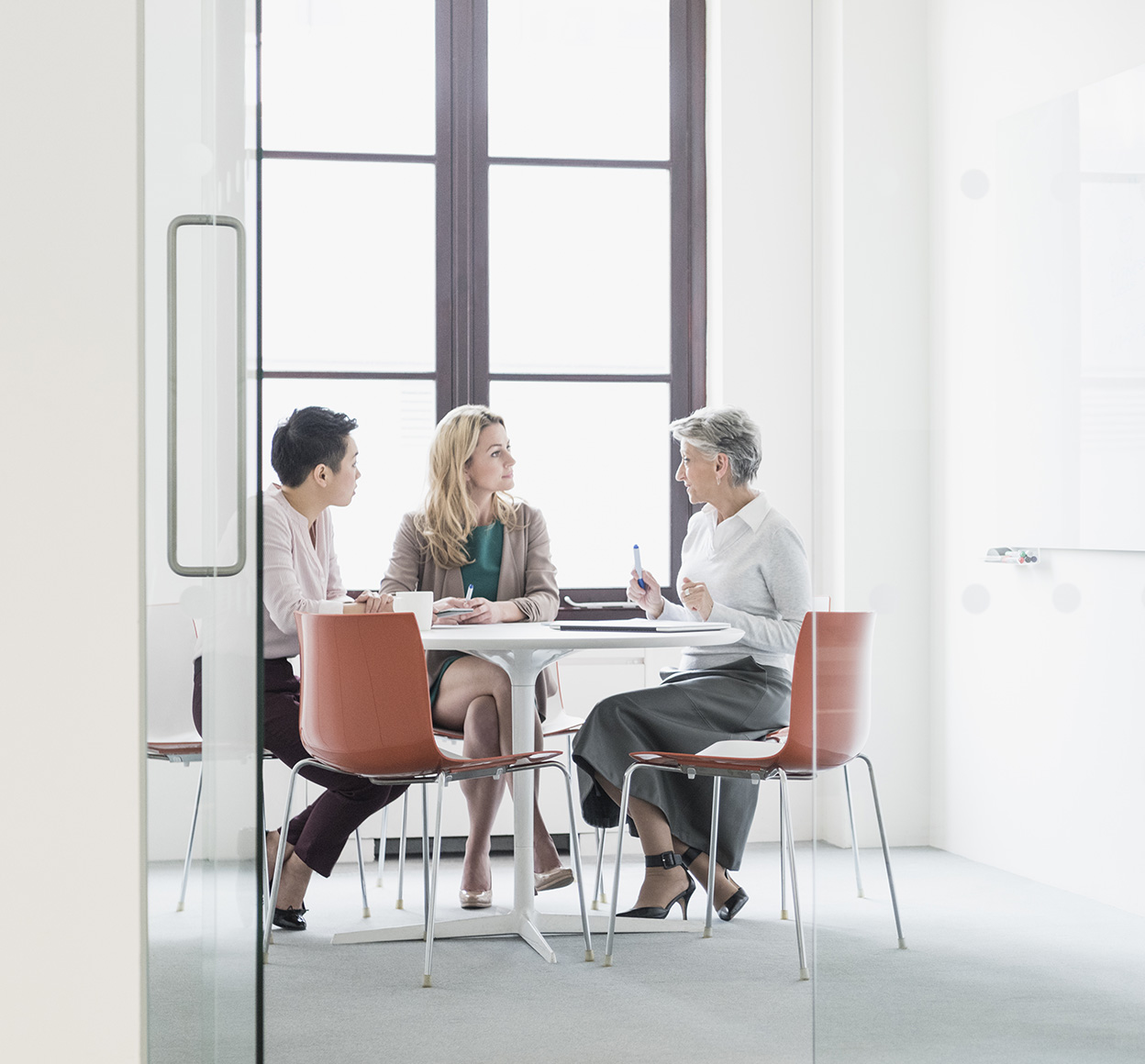 Three businesswomen hold a meeting in an office