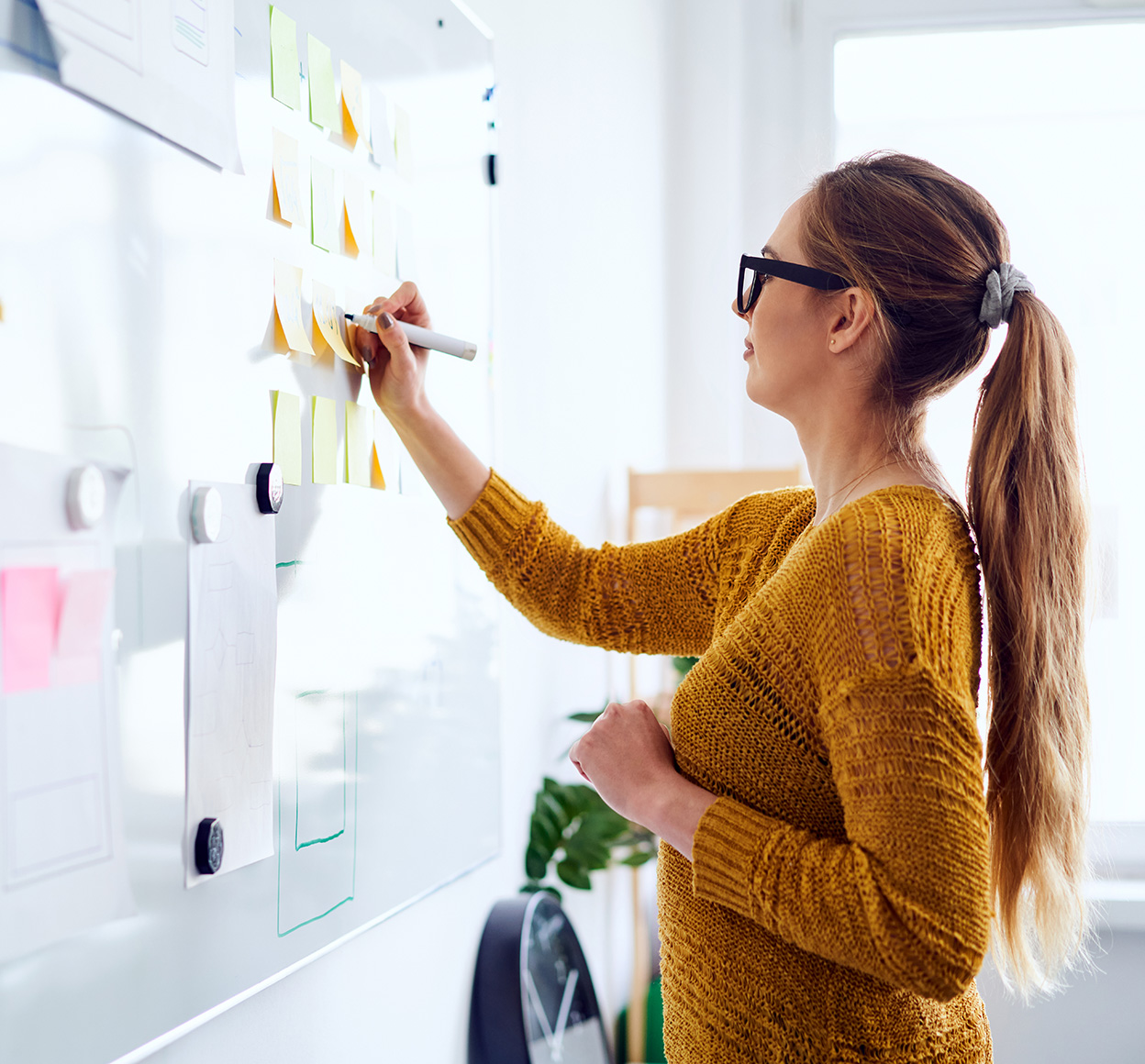 Woman writing on a whiteboard during a brainstorming session