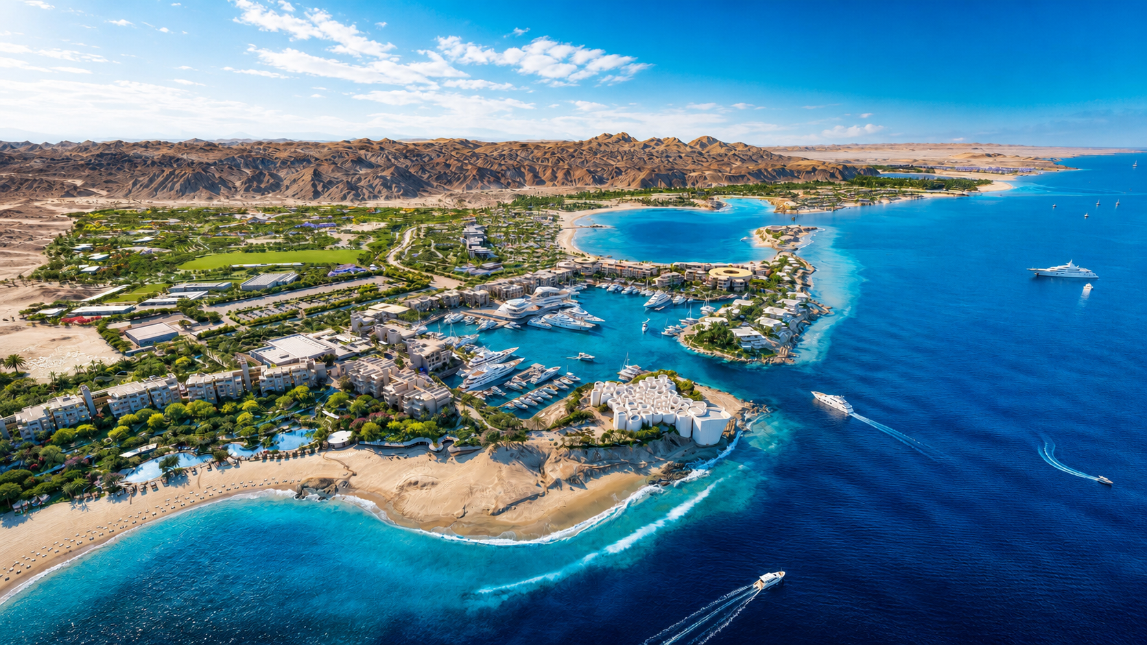 Aerial view of Amaala’s coastal resort, with turquoise bays, luxury residences, yachts, beaches, and desert mountains. 