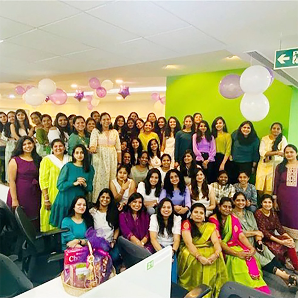 Indian women pose for a team photo in their office.