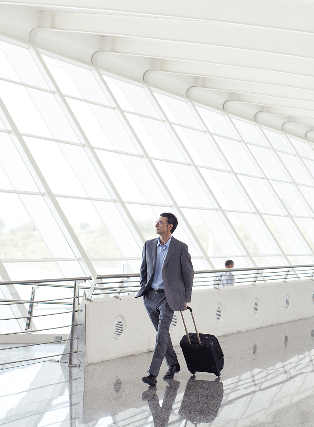 Homme d’affaires marchant dans un aéroport avec ses bagages.