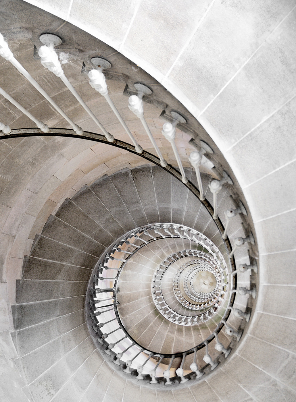 Looking down a stone spiral staircase.