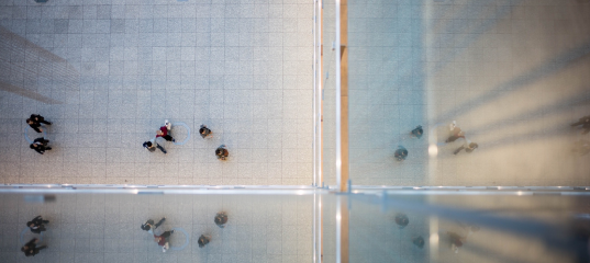 Photo of view looking down at people walking in business building courtyard