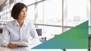 business woman sitting at her desk next to an office window